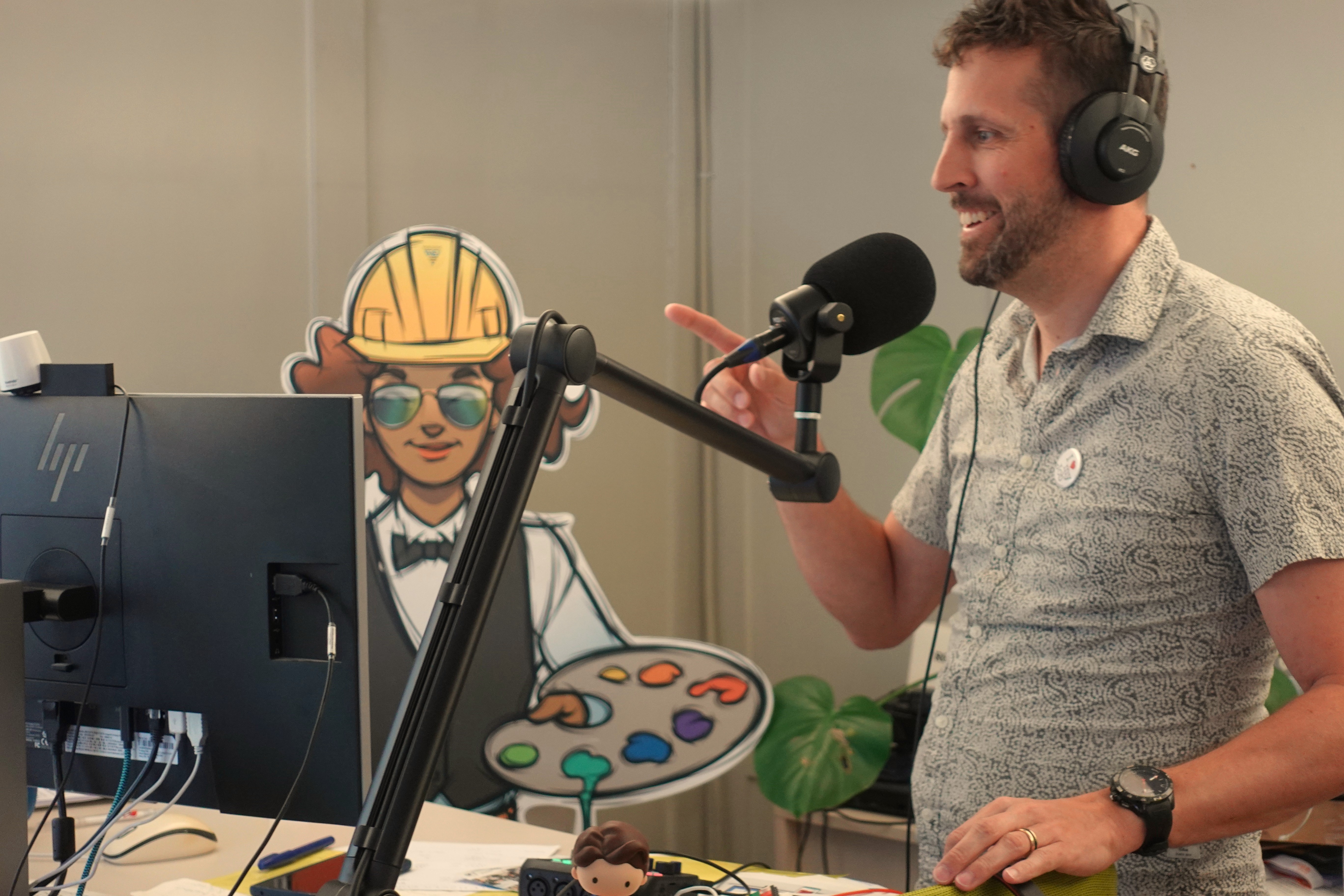 Ein Bild des Büroarbeitsplatz mit Mikrofon und Simon Schmid.